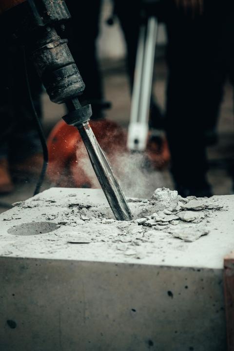 Jackhammer chisel breaking into a concrete block